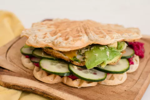 Waffles salados tipo sándwich con pepino, mayonesa de remolacha, palta, queso de máquina y huevo