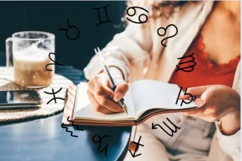 Mujer escribiendo en agenda con rueda zodiacal.