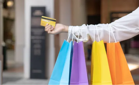 Una mujer con bolsas de colores en la mano