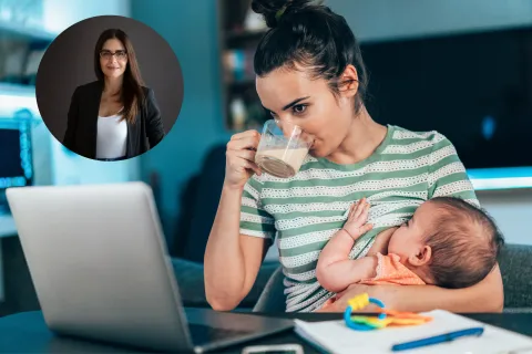 Una mamá dándole la teta a un bebé en frente a una computadora.