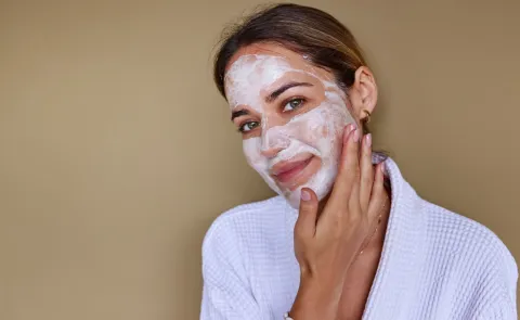Una mujer haciendose una mascarilla facial