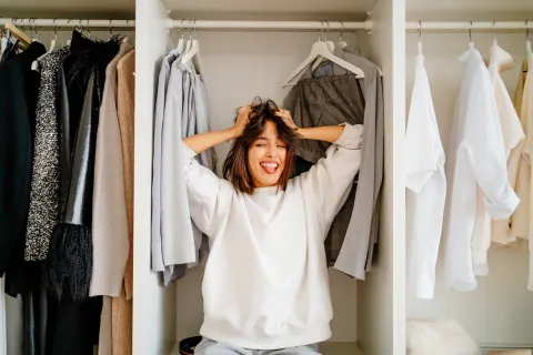 Foto de mujer ordenando ropa.
