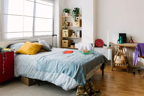 En ambientes pequeños, ubicar la cama contra una pared o en una esquina puede liberar espacio central y permitir una circulación más cómoda.