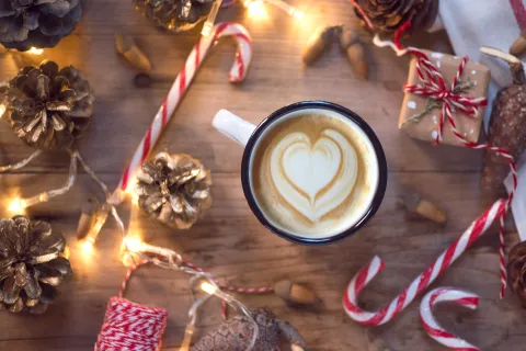 Una taza de café sobre una mesa decorada para Navidad