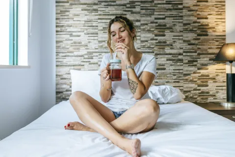 mujer bebe té en la cama