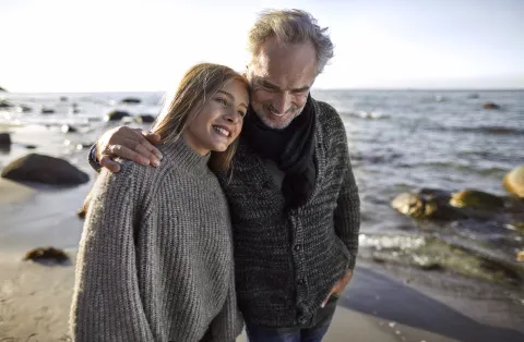 padre e hija caminan en la playa