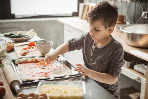 un nene cocina pizza