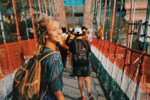 Cruzando el puente que une los mundos de Rishikesh, cuidando que los monos no le saquen la comida de la mochila.