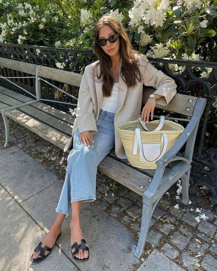 Un look muy casul y urbano. Top básico, jean recto, sandalias planas, blazer y canasta con detalle en cuero, todo en paleta neutra.