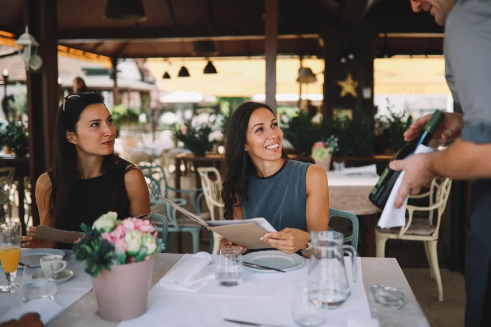 mozo y dos mujres en un restaurante