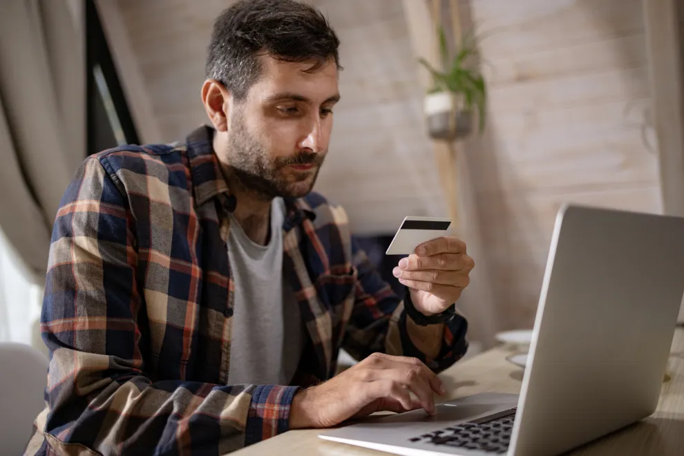 hombre joven comprando con tarjeta de crédito