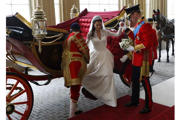 Kate, ahora Duquesa de Cambridge, es ayudada a bajar de la carroza en la entrada del Palacio de Buckingham