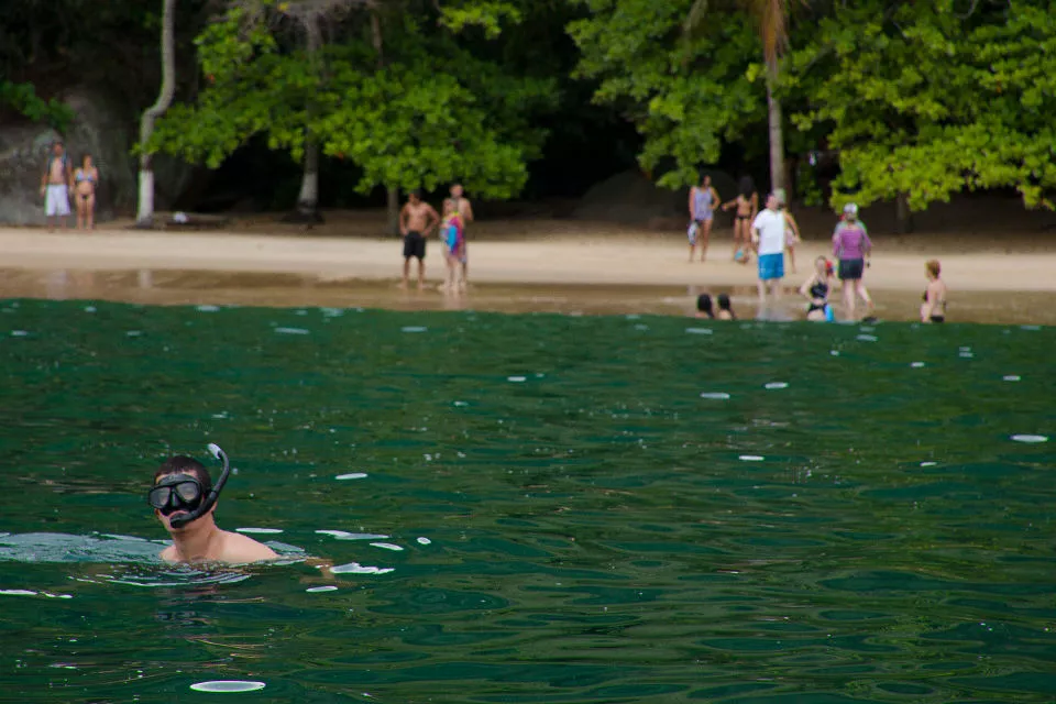 Un turista bucea luego de lanzarse desde el barco, en una de las islas de la bahía de Paraty